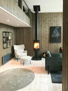 a living room with a couch and a fireplace at Large Cabin Near Hardangervidda With Sunny Veranda in Veggli