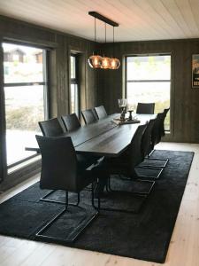 a dining room with a large wooden table and chairs at Large Cabin Near Hardangervidda With Sunny Veranda in Veggli