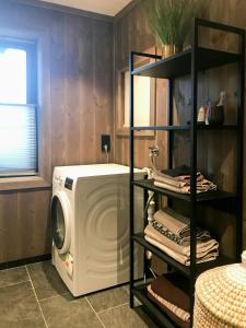 a laundry room with a washing machine and a shelf at Large Cabin Near Hardangervidda With Sunny Veranda in Veggli
