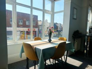 a table with chairs and a vase of flowers on it at Portslade Station House in Brighton & Hove
