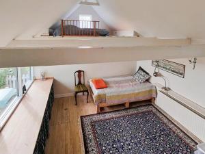 a attic room with a couch and a chair at Spacious Holiday Gem With A View Over Præstø Fjord in Faxe