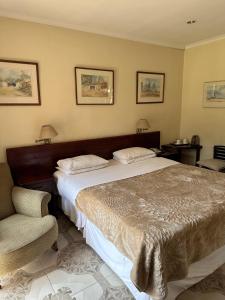 a bedroom with a large bed and a chair at A boutique lodge situated in a serene environment - 2030 in Harare