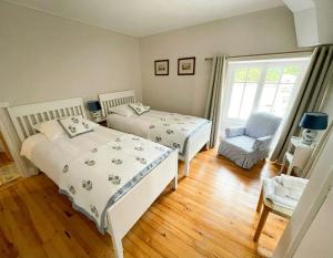 a bedroom with two beds and a chair and a window at Stone Manor House In Quercy in Belvèze