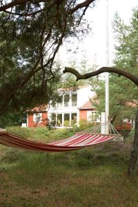 a hammock in a yard in front of a house at Red Stone House By Dueodde Beach in Neksø
