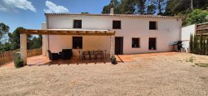 Casa bianca con patio, tavolo e sedie di Cortijo Castillo de peñafleita a Siles