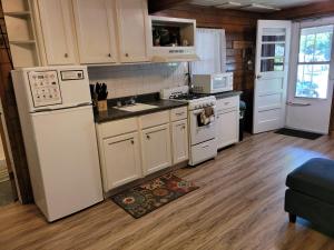 una cucina con elettrodomestici bianchi e pavimento in legno di Castaways Cottage on Croton Pond #2 a Newaygo