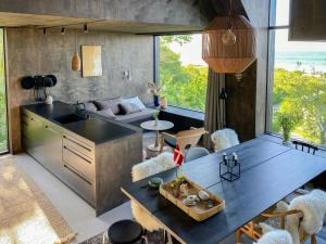 a kitchen and living room with a table and a couch at Beach-Close Summer House With Panoramic View in Allingåbro +30 photos