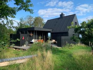 a black house with a black roof at Beach-Close Summer House With Panoramic View in Allingåbro