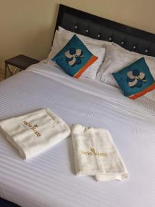 Una cama blanca con toallas encima. en Drift and Dream, en Syokimau