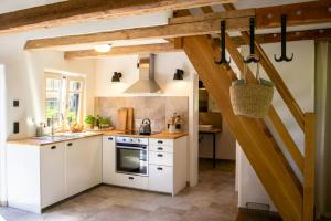 a kitchen with white cabinets and wooden beams at Oasis Of Peace Near The Lake in Langen Jarchow
