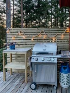 a grill on a deck with a picnic table and a bench at Lakeside Holiday Home With Sauna Near Karlskoga in Karlskoga