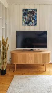 a flat screen tv sitting on top of a wooden coffee table at Holiday Home Idyll By Roskilde Fjord in Kirke-Hyllinge