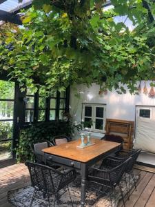 a wooden table and chairs on a patio at Country House With Large Garden On Langeland in Humble