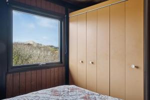 洛肯70'S Style Summerhouse Near Løkken的卧室设有窗户和1张床