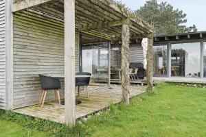 a wooden deck with a table and chairs on a house at Family Time At Sea Air Nature By Ebeltoft Bay in Ebeltoft