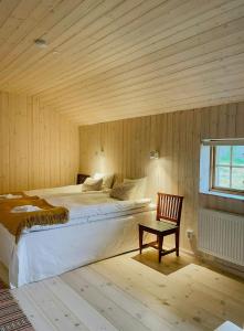 a bedroom with two beds and a chair and a window at Active Holiday In Dalarnas Gopshus in Blyberg