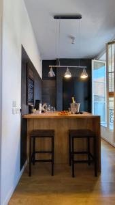 une cuisine avec un bar avec deux tabourets dans une pièce dans l'établissement Kalu Studio 8 - Studio cosy Centre médiéval Sarlat, à Sarlat-la-Canéda 19 autres photos