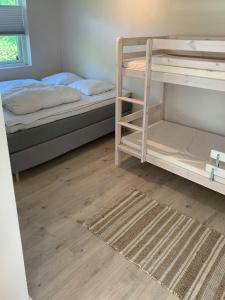 une chambre avec deux lits superposés et un tapis dans l'établissement Modern Cottage Near North Zealand's Beaches, à Smidstrup