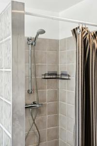 a shower with a shower head and a shower curtain at Family Idyll Near Kikhavn Beach in Kikhavn