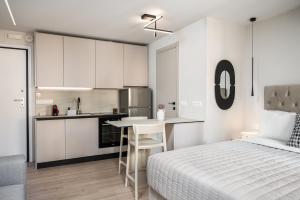 a white bedroom with a bed and a kitchen at Old Town Elegant suite in Corfu