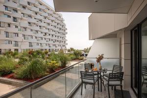 a balcony with a table and chairs and a building at Ambient in Infinity Pool & Spa Resort in Mamaia