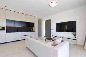 a living room with a white couch and a tv at Cloud 9 D3 in Tkon