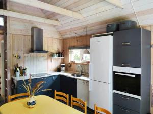 a kitchen with a table and a white refrigerator at Home Near Beach With Wilderness Bath in Sindrup