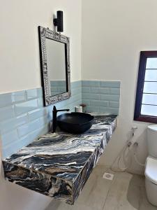 a bathroom with a black sink and a mirror at Tulivu Zanzibar in Bwejuu +24 photos