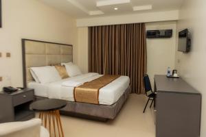 una camera d'albergo con un letto e una scrivania di Romeneo Grand Royal Hotel a Lagos