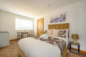 a bedroom with a large bed and a table at -RD7B- For your relaxed and Cosy stay with Free WiFi in Batley