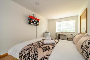 a bedroom with a bed with a black and white blanket at -RD7B- For your relaxed and Cosy stay with Free WiFi in Batley +11 photos