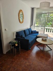 a living room with a blue couch and a table at apt granalacante in Gran Alacant +8 photos