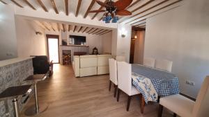 una sala da pranzo con tavolo, sedie e ventilatore a soffitto di Cortijo Castillo de peñafleita a Siles