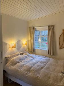un lit dans une chambre avec une fenêtre dans l'établissement Cottage Near Beach Perfect For Families, à Højby