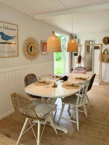 une salle à manger avec une table et des chaises blanches dans l'établissement Cottage Near Beach Perfect For Families, à Højby