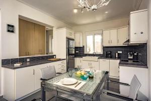 a kitchen with a glass table and white cabinets at Villa Keshi in Tragaki