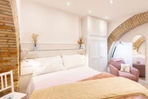 a bedroom with a large bed and a chair at Center Boutique in Cagliari