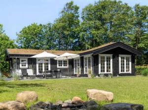 una casa en blanco y negro con un patio de césped en Scandinavian-Style Summer House By Liseleje Beach, en Liseleje