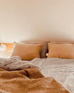 an unmade bed with two pillows on top of it at Tradition Meets Modern In Gulf House in Ostermarsch