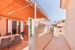 eine Terrasse mit einer hölzernen Pergola sowie einem Tisch und Stühlen in der Unterkunft Puerta Marina Costa de la Luz in La Redondela