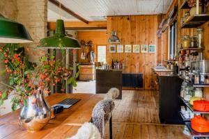 a kitchen with wooden walls and a wooden table at Restored Quarry House Near Nobel Laureate Home in Lönsboda +28 photos
