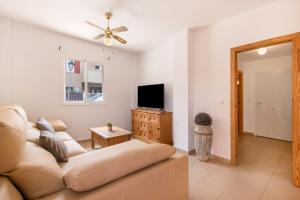 ein Wohnzimmer mit Sofa und Fernseher in der Unterkunft Puerta Marina Costa de la Luz in La Redondela