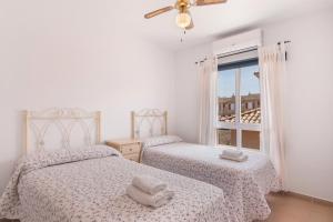 zwei Betten in einem weißen Zimmer mit Fenster in der Unterkunft Puerta Marina Costa de la Luz in La Redondela + 22 Fotos