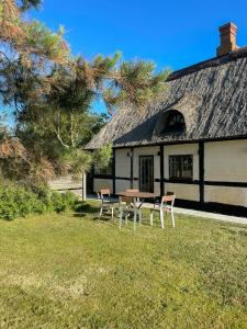 een tafel en stoelen voor een huis bij Bindingsværkshus Med Udsigt På Samsø in Nordby