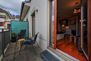 a balcony with a table and chairs and a kitchen at Hluboká Apartment in Hluboká nad Vltavou