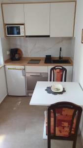 a small kitchen with a white table and chairs at Apartment Rakić Pomer in Pomer