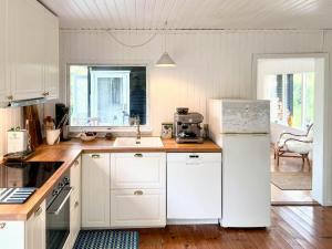 a kitchen with white cabinets and a white refrigerator at Get Close To Nature And The Starry Sky in Stege