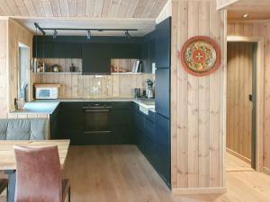 una cocina con armarios de color verde oscuro y una placa en la pared en Cozy Ambiance And Trails At Skeikampen, en Svingvoll
