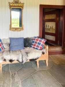a living room with a fur couch and a mirror at Spacious Family Cabin Near Nordre Syndin in Ryfoss