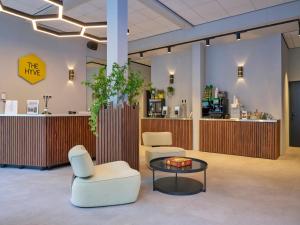 a lobby with two chairs and a table and a counter at The Hyve Capsule Amsterdam in Amsterdam +26 photos